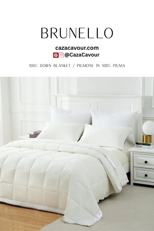 Elegant white bed with plush down blanket and pillows in a modern, minimalist bedroom setting