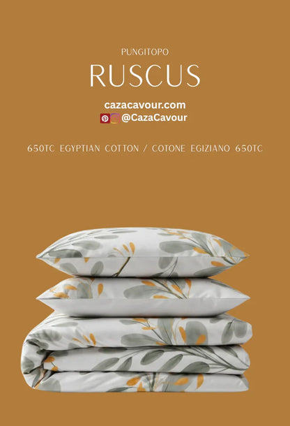 Stack of Egyptian cotton bedding with green and gold botanical print on a brown background